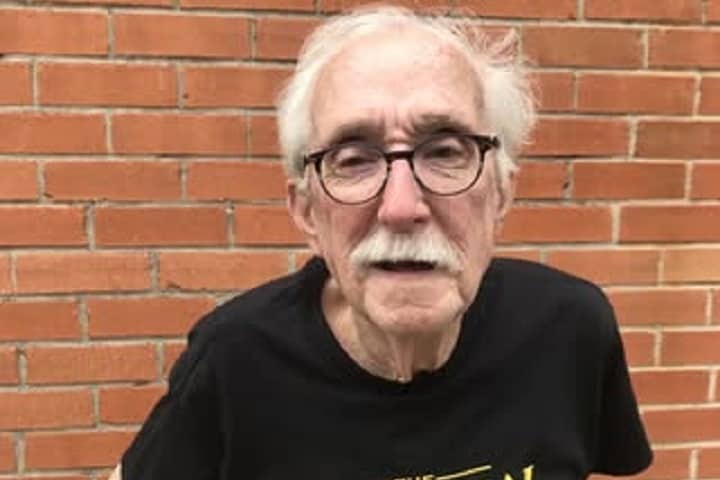 Andy Huggins smiling in a casual photo, wearing a t-shirt and glasses.